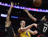 Los Angeles Lakers guard Alex Caruso, center, passes the ball as Los Angeles Clippers guards Shai Gilgeous-Alexander, left, and Garrett Temple defend during the second half of an NBA basketball game Friday, April 5, 2019, in Los Angeles. The Lakers won 122-117. (AP Photo/Mark J. Terrill)