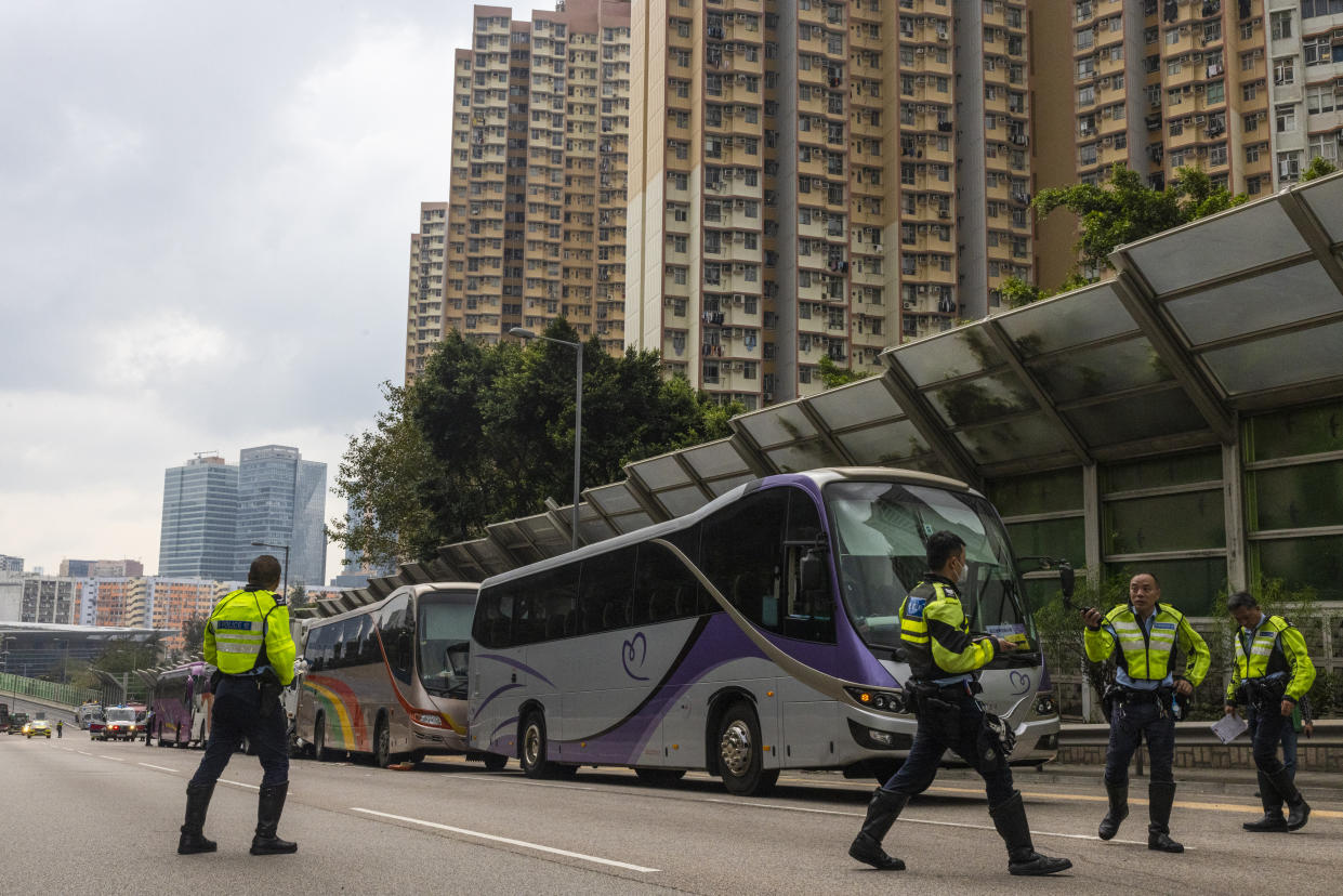 Police inspect after an accident on a highway in Hong Kong, Friday, March 24, 2023. Four passenger buses and a truck collided near a Hong Kong road tunnel Friday, injuring dozens of people. (AP Photo/Louise Delmotte)