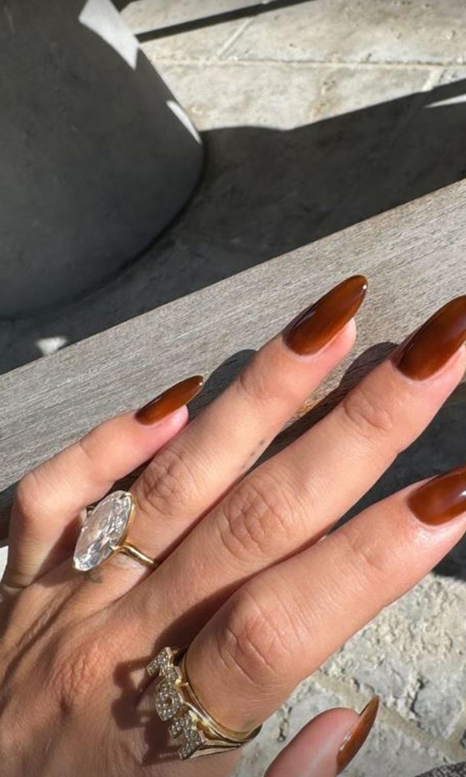 Manicura otoñal de Hailey Bieber con anillo MOM