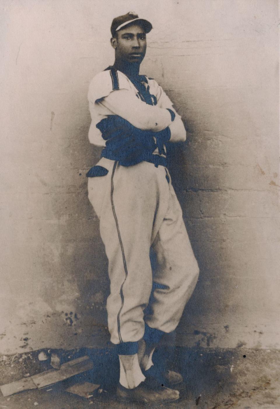 martin dihigo leaning against a wall with a baseball glove