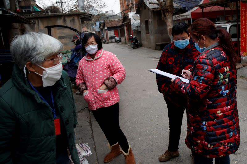 Members of a neighbourhood committee register locals and ask about therr travel history in Jiujiang