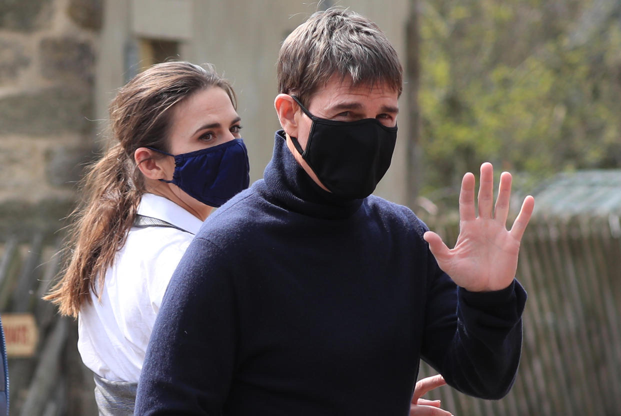 Actor Tom Cruise waves to onlookers as he walks to the set of his latest project, which is filming in the sidings of the railway station in the village of Levisham in the North York Moors. Picture date: Tuesday April 20, 2021.
