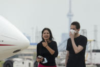 Michael Kovrig, right, talks with his wife Vina Nadjibulla, center left, after his arrival at Pearson International Airport in Toronto, Saturday, Sept. 25, 2021. China, the U.S. and Canada completed a high-stakes prisoner swap Saturday with joyous homecomings for Kovrig and Michael Spavor, two Canadians held by China and for an executive of Chinese global communications giant Huawei Technologies charged with fraud. (Frank Gunn /The Canadian Press via AP)