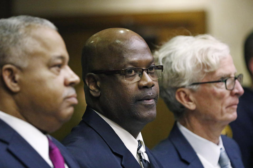 Defendant Curtis Flowers, center, stands with his attorneys Henderson Hill, left, and Rob McDuff at his bail hearing in Winona, Miss., Monday, Dec. 16, 2019. Flowers has been tried six times for murder in the 1996 shooting deaths of four people in a furniture store. Although sentenced to death during the sixth trial, the U.S. Supreme Court overturned that conviction in June, finding that prosecutors had shown a pattern of improperly excluding African American jurors in the trials. Flowers was granted bail. (AP Photo/Rogelio V. Solis)