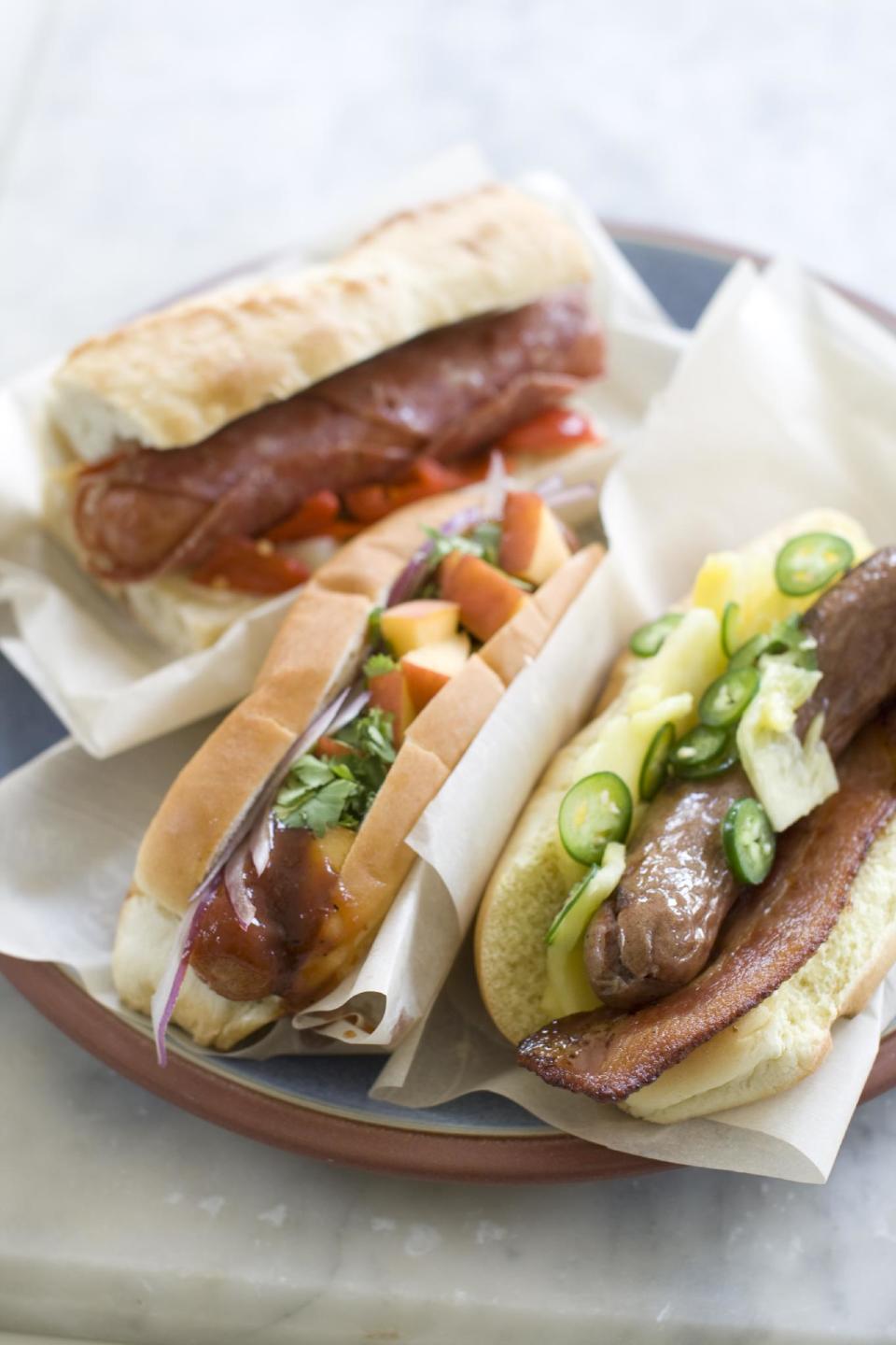 This June 29, 2013 photo shows, from top, the Italian, sweet peach and Hawaiian hot dogs in Concord, N.H. (AP Photo/Matthew Mead)