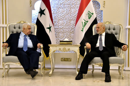 Iraq's Foreign Minister Ibrahim al-Jaafari (R) meets with his Syrian counterpart Walid al-Muallem at Baghdad airport August 25, 2016. Iraqi Foreign Minister Office/Handout via REUTERS