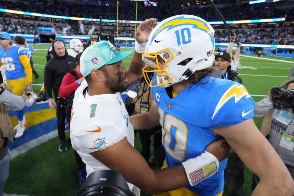 Miami Dolphins quarterback Tua Tagovailoa (1) and Los Angeles Chargers quarterback Justin Herbert (10) shake hands after the game at SoFi Stadium.