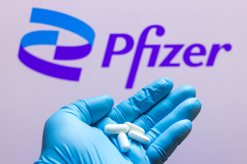 BRAZIL - 2021/11/26: In this photo illustration a Pfizer logo is seen on a screen and a hand holding pills. (Photo Illustration by Rafael Henrique/SOPA Images/LightRocket via Getty Images)