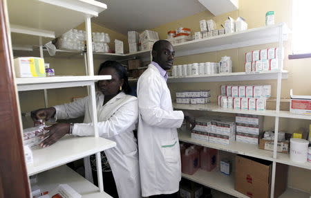 Pharmacists Michael Otieno and Ruth Munyao arrange anti-retroviral (ARV) drugs on a shelf in the pharmacy at the Mater Hospital in Kenya's capital Nairobi, September 10, 2015. REUTERS/Thomas Mukoya