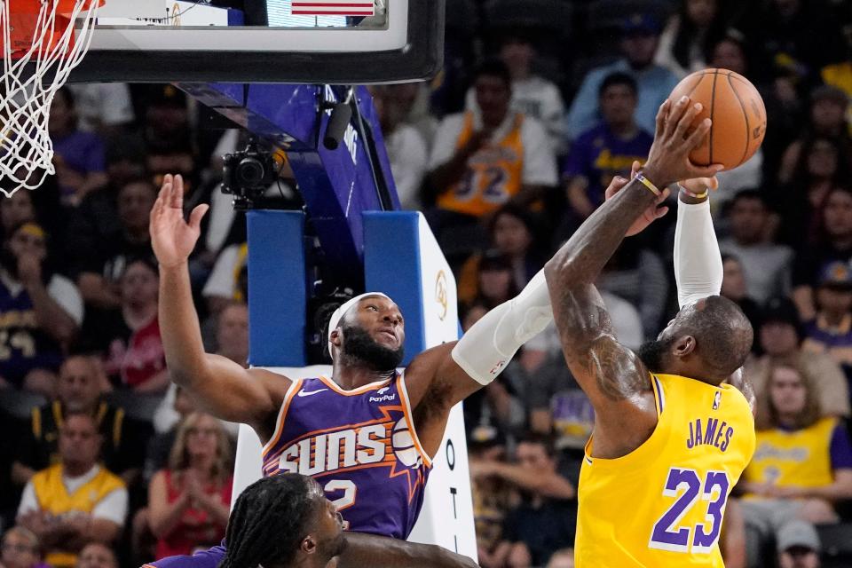 Los Angeles Lakers forward LeBron James (right) grabs a rebound away from Phoenix Suns forward Josh Okogie during the first half of an NBA preseason basketball game on Oct. 19, 2023, in Thousand Palms, Calif.