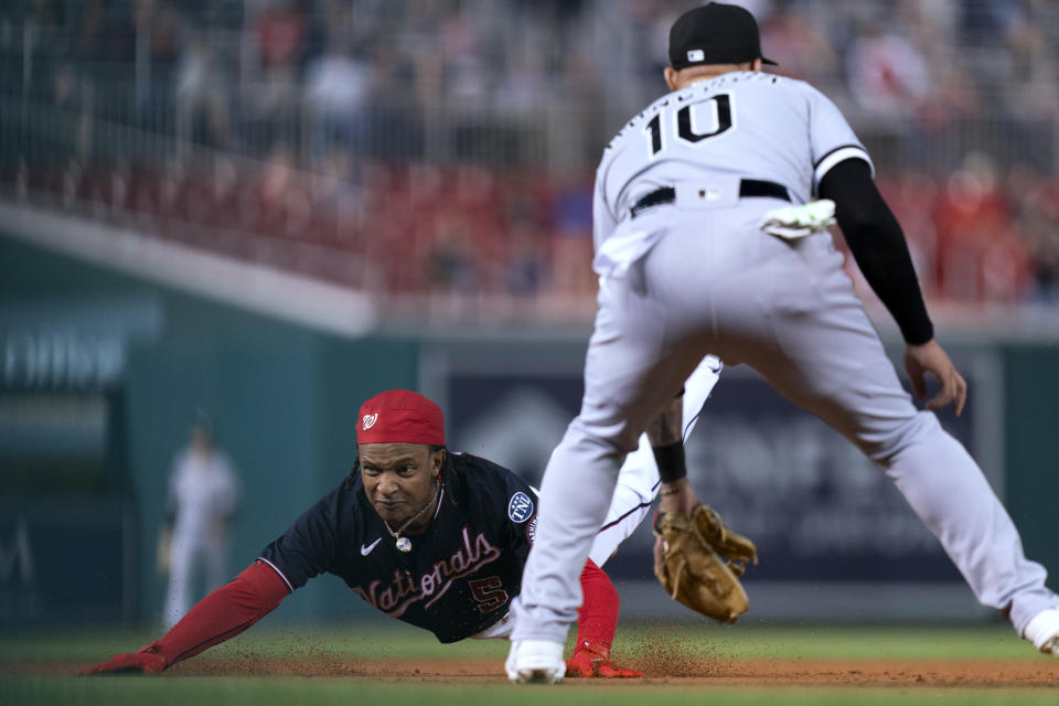 Washington Nationals' CJ Abrams, left, dives toward third base in front of Chicago White Sox third baseman Yoan Moncada after hitting triple during the first inning of a baseball game Tuesday, Sept. 19, 2023, in Washington. (AP Photo/Stephanie Scarbrough)