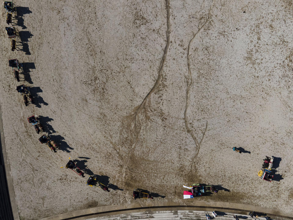 Faithful in horse-drawn carriages wait in a line to be blessed with "holy water" during a celebration in honor of the Virgin del Carmen, patron saint of Chile, in Santiago, Chile, Saturday, July 16, 2022. Hundreds of cowboys in woolen ponchos and families on wooden horse carts lined up to receive a priest's blessing in the huge esplanade in front of the National Sanctuary of Maipu on Saturday afternoon. (AP Photo/Esteban Felix)