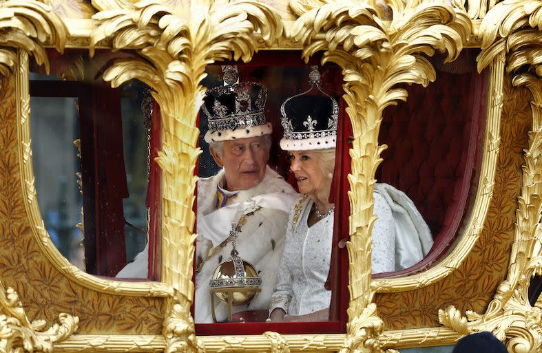 king charles and queen camilla travelling in the gold state coach