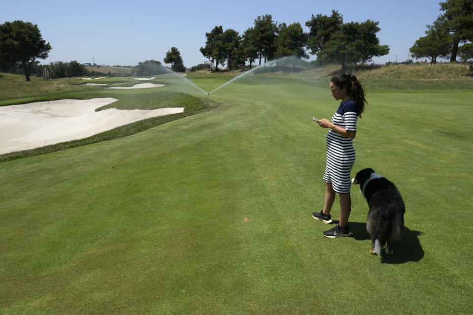 Lara Arias, a rare female golf course superintendent, checks the water sprinklers trough a phone app during an interview with the Associated Press, at the Marco Simone Club in Guidonia Montecelio, Italy, Tuesday, July 11, 2023. When Lara Arias started her job as course superintendent at the Marco Simone golf club outside Rome that will host the Ryder Cup from Sept. 29 to Oct.1 there was hardly any grass to manicure, no bunkers to rake and nary a green to shape, the entire course was practically one big pile of dirt amid a complete restyling. (AP Photo/Alessandra Tarantino)