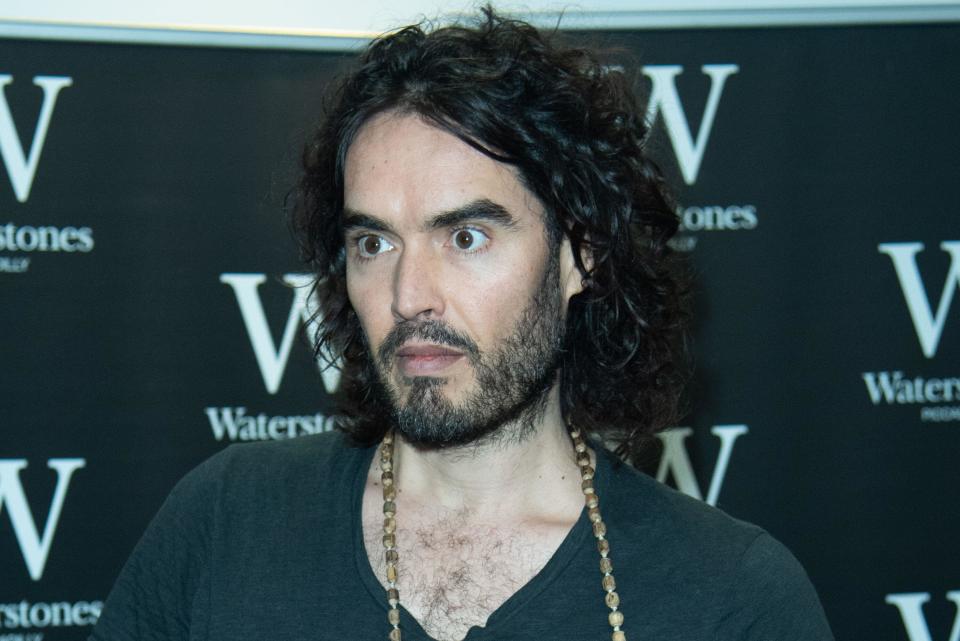 London, England. December 5, 2014. Comedian Russell Brand signs copies of his books 