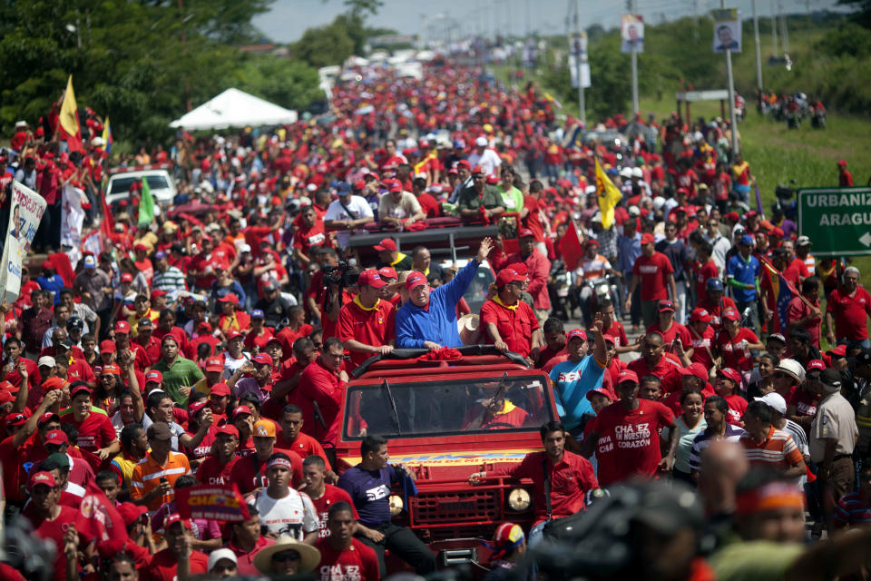 Venezuela's President Hugo Chavez waves to supporters from the top of a vehicle driven by Venezuela's Foreign Minister Nicolas Maduro during a campaign caravan from Barinas to Caracas, in Sabaneta, Venezuela, Monday, Oct. 1, 2012. Venezuela's presidential election is scheduled for Oct. 7. (AP Photo/Rodrigo Abd)