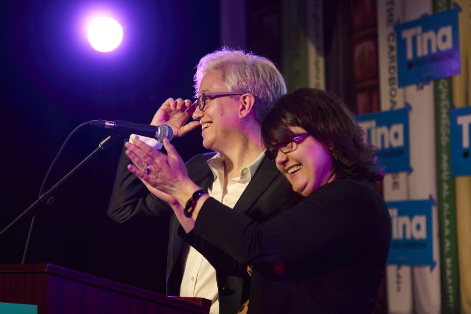 Democratic gubernatorial candidate Tina Kotek, left, and her wife Aimee Kotek Wilson smile while speaking to supporters before the results of Oregon's primary election are announced in Portland, Ore., Tuesday May 17, 2022. (AP Photo/Craig Mitchelldyer)