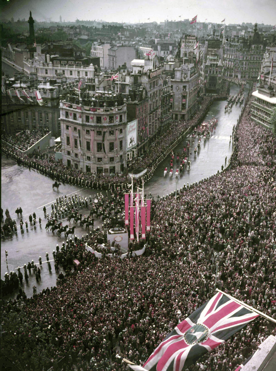 FILE - The Golden Coach, with the newly crowned Queen Elizabeth II inside, passes through Trafalgar Square, London, June 2, 1953, on the processional drive following the Coronation of the Queen in Westminster Abbey. Britain’s royal family turns the page on a new chapter with the coronation of King Charles III. Charles ascended the throne when his mother, Queen Elizabeth II, died last year. But the coronation Saturday is a religious ceremony that provides a more formal confirmation of his role as head of state and titular head of the Church of England. (AP Photo/ Dennis -Lee Royle, File)