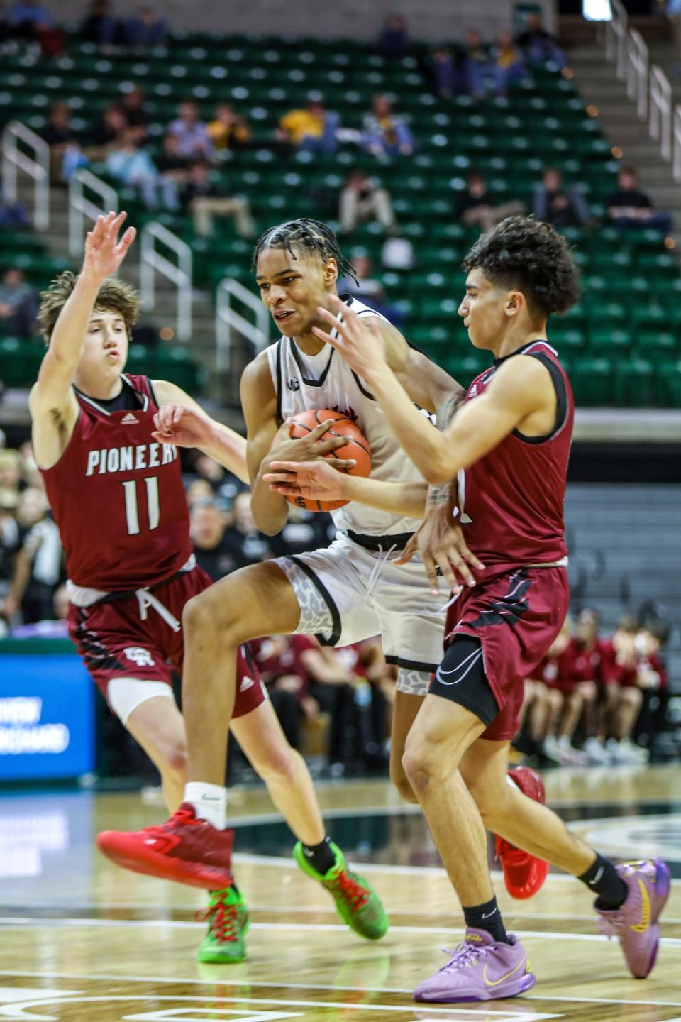 Detroit Old Redford's Jaquan Stennis Jr. drives against Riverview Gabriel Richard's Drew Everingham and Derek Lesko during the Michigan High School Athletic Association boys basketball division 3 semifinals at Breslin Center in East Lansing on Thursday, March 14, 2024.