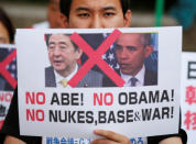 <p>A Japanese protester holds a placard to protest against President Barack Obama and Japanese Prime Minister Shinzo Abe, at the Peace Memorial Park in Hiroshima, Japan May 26, 2016 a day before the leaders arrive in the city. (Photo: Toru Hanai/Reuters) </p>