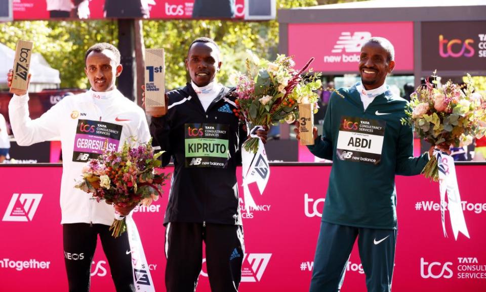 Amos Kipruto is flanked by second-placed Leul Gebresilase of Ethiopia and third-placed Bashir Abdi of Belgium