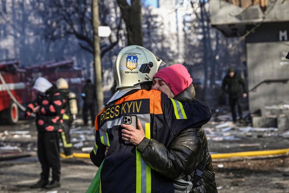 Menschen umarmen sich vor einem beschädigten Wohnhaus in Kiew, nachdem bei Angriffen auf Wohngebiete mindestens zwei Menschen getötet wurden. 15. März 2022