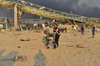 People carry a wounded man after a fire at a warehouse with explosives at the Port of Beirut led to massive blasts in Beirut, Lebanon on August 4, 2020. A large number of people were reportedly injured in the blasts, while former Prime Minister Saad al-Hariri -- who lives near the area of the explosions -- is said to be unharmed, according to initial reports. (Photo by Houssam Shbaro/Anadolu Agency via Getty Images)