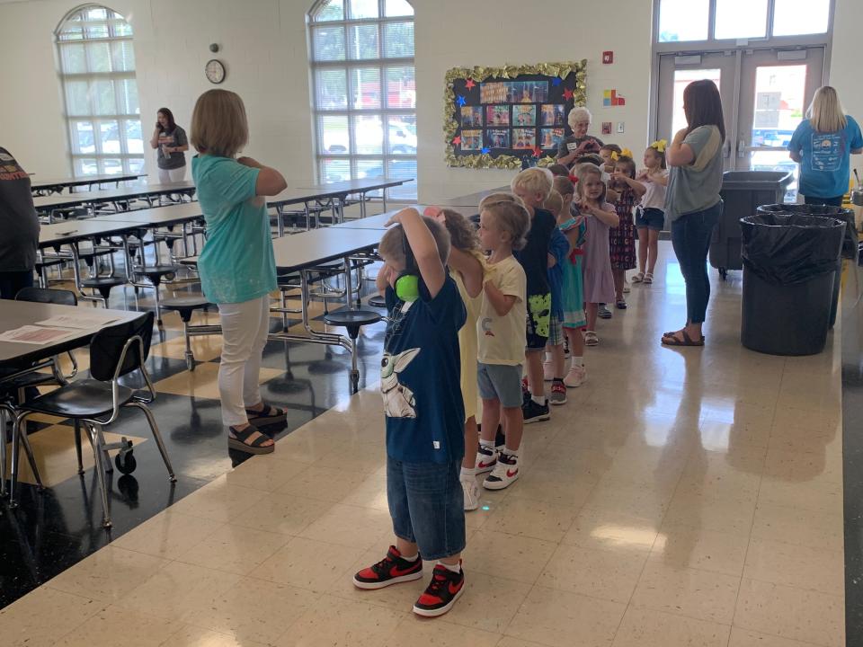 Kindergarteners at Glencoe Elementary School use their time in the cafeteria to learn how to stand in a line.