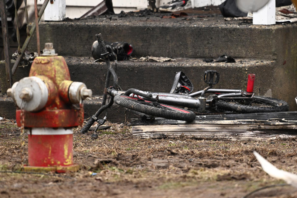 A bicycle sits at the foot of the front steps to a home, Wednesday, Jan. 3, 2024, in Somers, Conn., in the aftermath of a fatal fire. Four children died Tuesday night in a fire that broke out in the two-family home. The children, ages 5, 6, 8 and 12, were found inside the house where 11 people lived, fire and town officials said. (AP Photo/Jessica Hill)