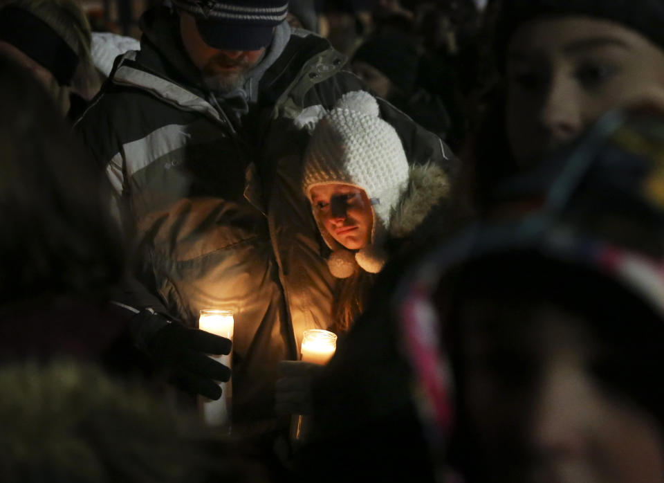 Jason Shaw comforts his daughter Ryley, 10, in honor of Kate Kasten, her children, Zoe Kasten, 8, and Jonathan Kasten, 10, and Kate Kasten's mother, Jane Moeckel, 61, at Harris Elementary School in St. Charles, Mo., Sunday, Dec. 30, 2018. Prosecutors say a St. Louis-area man charged with fatally shooting his girlfriend, her two young children and her mother could face the death penalty once the investigation is complete. (Laurie Skrivan/St. Louis Post-Dispatch via AP)