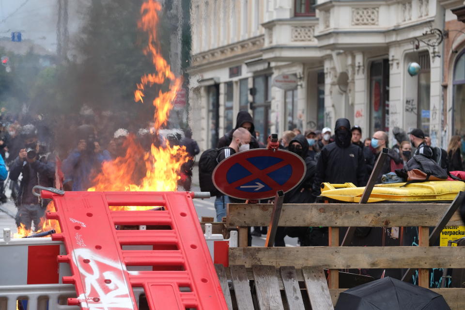 FILE - In this Sept. 18, 2021 file photo, masked participants stand behind a barricade in Leipzig, Germany. After the official end of the "We are all LinX" demonstration, barricades were erected and set on fire in the Connewitz district of Leipzig. The German Journalists Association on Monday condemned attacks by police against reporters covering a far-left protest in the eastern city of Leipzig on Saturday. (Sebastian Willnow/dpa via AP)