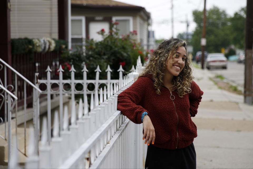 In this June 11, 2020, photo Ashly Estevez-Perez, a recent graduate of Rutgers-Camden, smiles during an interview in Camden, N.J. Estevez-Perez, who was born in the Dominican Republic, has spent most of her life in Camden. Estevez-Perez marched in Camden's Black Lives Matter protest May 30, and Police Chief Joe Wysocki helped carry the banner at the front of the pack. (AP Photo/Matt Slocum)