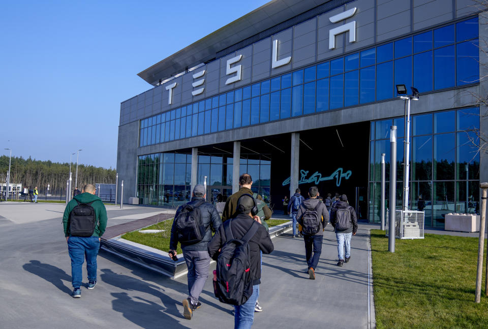 BESTAND - Mensen lopen op 13 maart 2024 de Tesla Gigafactory-fabriek voor elektrische voertuigen binnen in Gruenheide, nabij Berlijn, Duitsland. Na slechte verkopen in het eerste kwartaal te hebben gemeld, is Tesla van plan ongeveer een tiende van zijn personeelsbestand te ontslaan in een poging om de kosten te verlagen .  Dat melden meerdere mediakanalen maandag.  (AP Foto/Ibrahim Norouzi, bestand)