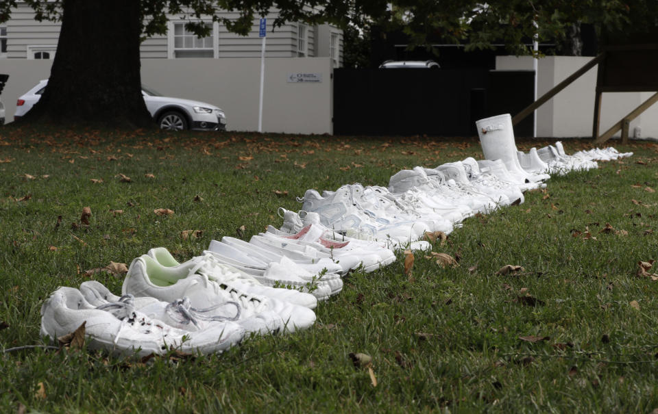 Fifty pairs of white shoes line up as a memorial to the victims of Friday March 15 mass mosque shootings in front of a church in Christchurch, New Zealand, Tuesday, March 19, 2019. Four days after Friday's attack, New Zealand's deadliest shooting in modern history, relatives were anxiously waiting for word on when they can bury their loved ones. (AP Photo/Mark Baker)