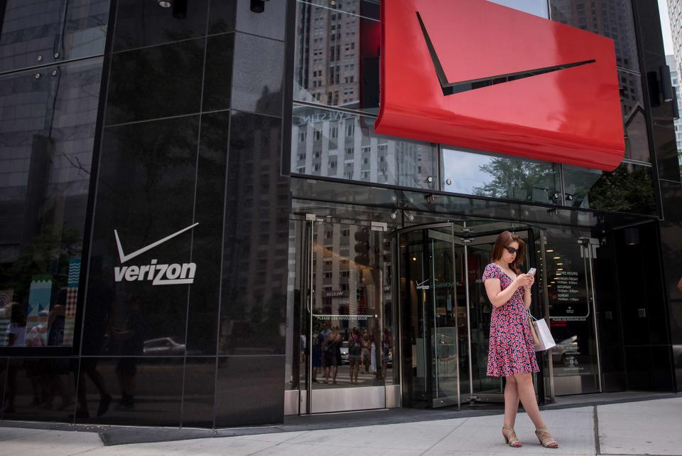 <span class="pb-caption">A pedestrian uses a smartphone outside a Verizon Communications store in downtown Chicago in July 2016. (Photo credit: Christopher Dilts/Bloomberg)</span>