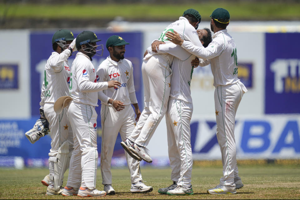 Pakistan's bowler Noman Ali, second right, lifts captain Babar Azam as they celebrate the dismissal of Sri Lanka's Angelo Mathews during the fourth day of the first cricket test match between Sri Lanka and Pakistan in Galle, Sri Lanka, Wednesday, July 19, 2023. (AP Photo/Eranga Jayawardena)