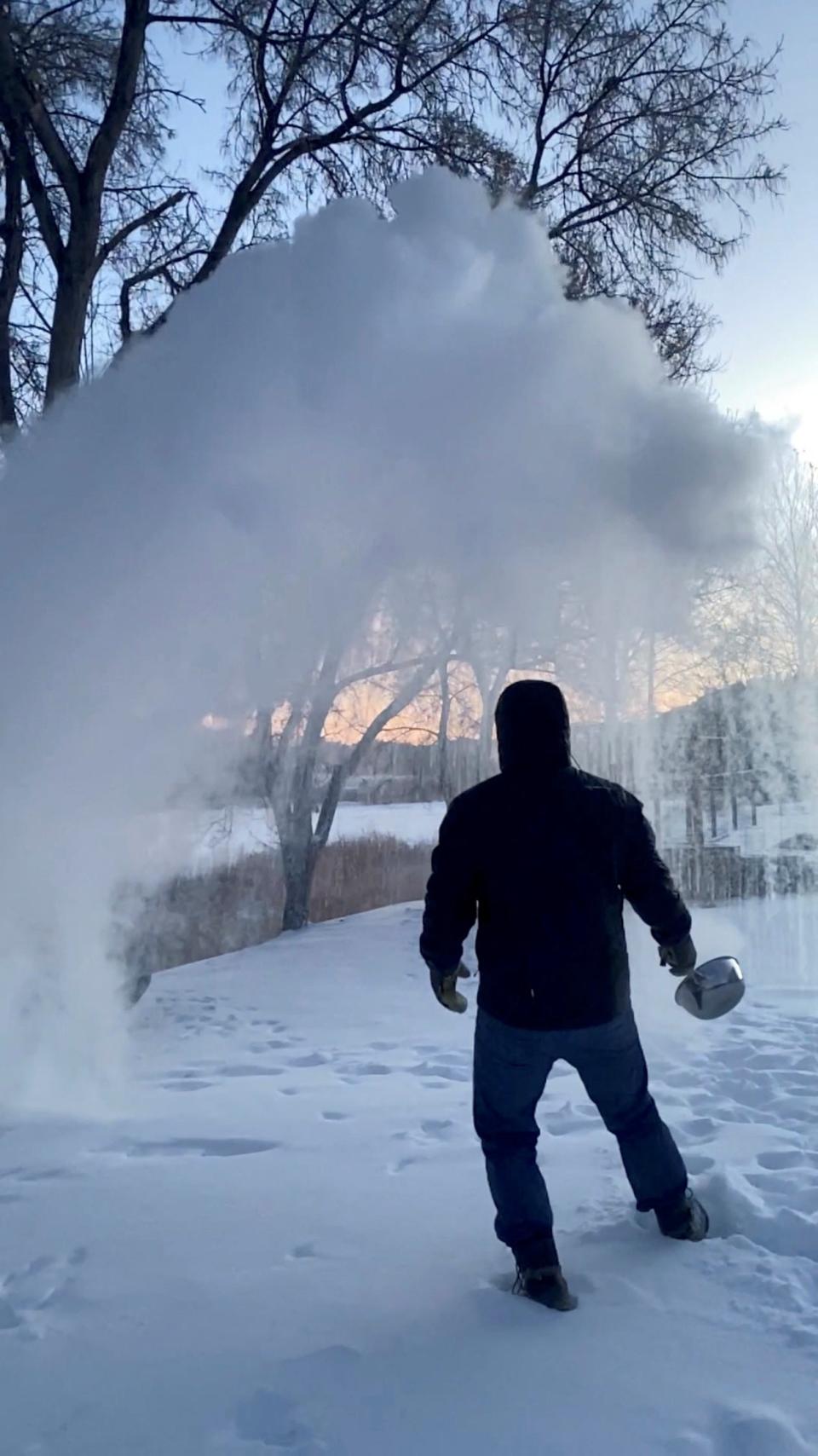 A man tosses hot boiling water in the snow in Carbon County, Montana on December 22 to show how it instantly freezes (@MEMENTOMORI_JMJ via REUTERS)