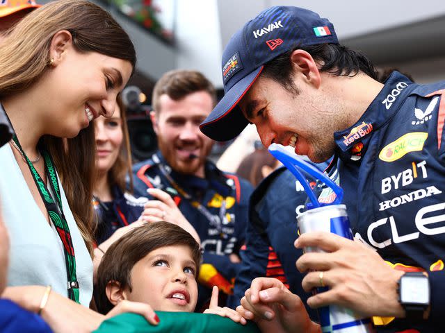 <p>Mark Thompson/Getty</p> Sergio Perez celebrates in parc ferme with Carola Martinez and their son Sergio Jr. during the F1 Grand Prix of Austria on July 02, 2023.