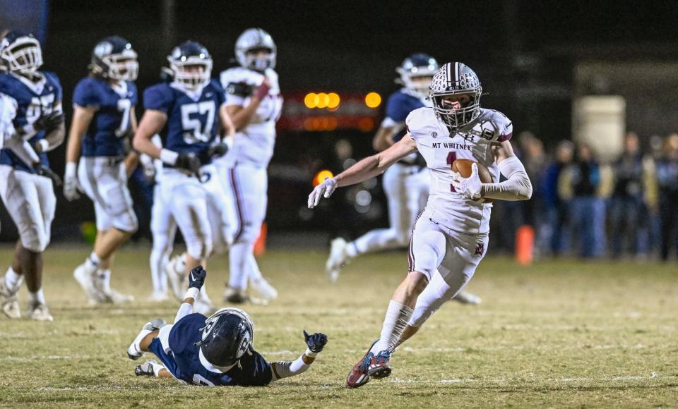 Mt. Whitney's Carter Myers escapes Redwood's Isaiah Galaviz in the 68th annual rivalry Cowhide game Friday, October 27, 2023.