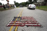 <p>A partially burned American flag lies on the street near the spot where Michael Brown was killed before an event to mark the one-year anniversary of the his death in Ferguson, Missouri August 9, 2015. (Rick Wilking/Reuters) </p>