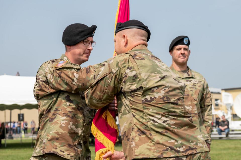 Sgt. Maj. Michael S. Riggs (left) receives the Tobyhanna Army Depot (TYAD) flag from Col. James L. Crocker (right), signifying his assumption of responsibility as Tobyhanna Army Depot Sgt. Maj. In the background, outgoing Depot Commander Col. Daniel L. Horn observes the military ceremony on June 29, 2023.