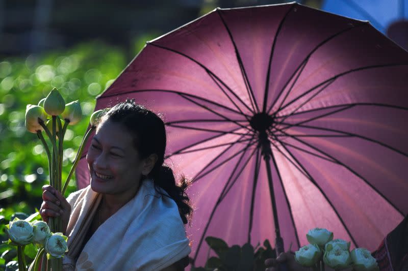 Una budista sostiene flores de loto mientras asiste al festival de la flor de loto, para marcar el final de la cuaresma budista, en Samut Prakan, Tailandia