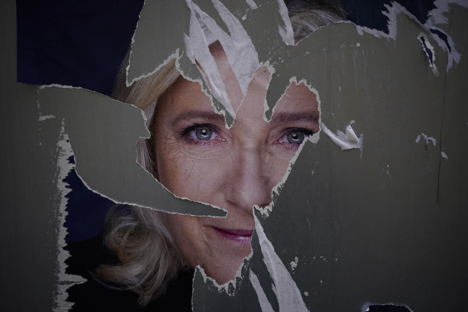 A defaced poster of French far-right presidential candidate Marine Le Pen is pictured in Marseille, southern France, Wednesday, April 13, 2022. French President Emmanuel Macron is facing a tougher-than expected fight for reelection. To win, Macron has hit the campaign trail at last — and it isn't always proving welcoming. (AP Photo/Daniel Cole)