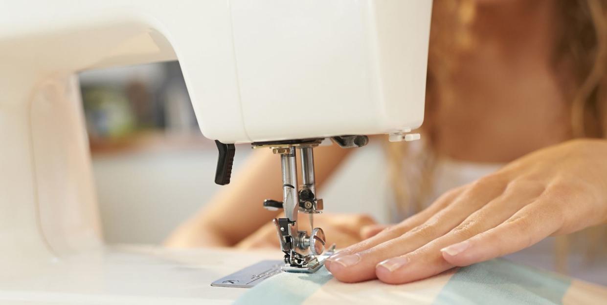 a woman using a sewing machine to sew fabric