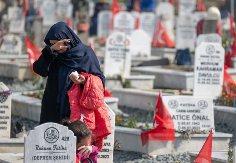 A woman mourns at her family's grave in a cemetery in Antakya. On the first anniversary of the 7.8-magnitude quake that struck last year. Boris Roessler/dpa