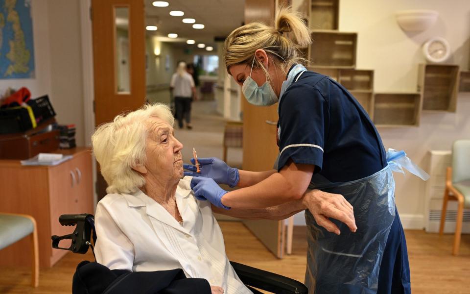 Practice Nurse Victoria Parkinson gives a dose of the Oxford-AstraZeneca Covid-19 vaccine to resident Ann Wilkinson, 94, at the Belong Wigan care home in Wigan, northwest England - OLI SCARFF/AFP