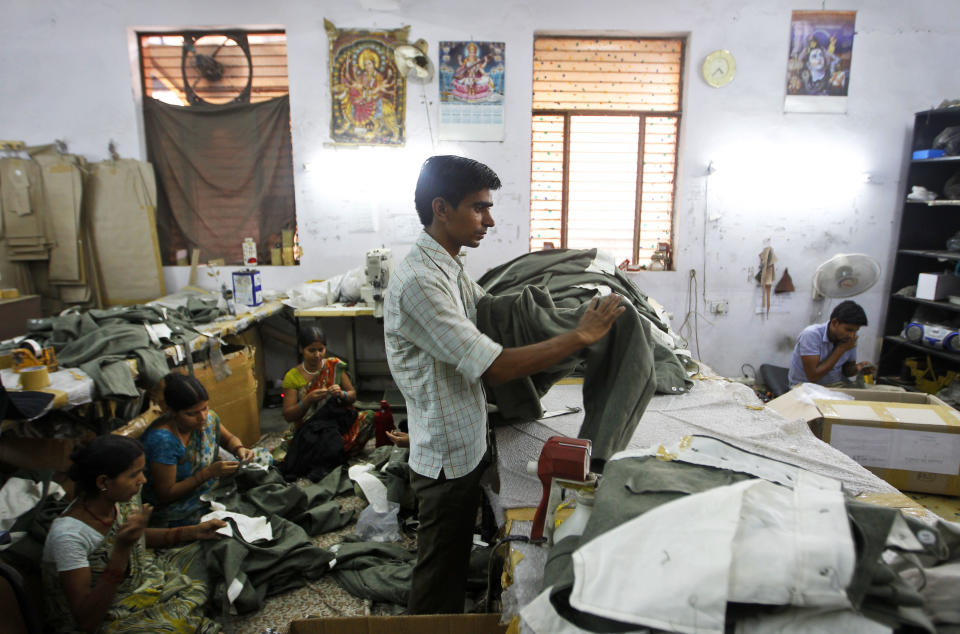 In this, June 2, 2012 photograph, posters of Hindu gods and goddesses adorn the wall as tailors and workers sew dresses being prepared for a reenactment of World War II at a workshop owned by Indian businessman Ashok Rai, unseen, in Sahibabad, India. From Hollywood war movies to Japanese Samurai films to battle re-enactments across Europe, Rai is one of the world's go-to men for historic weapons and battle attire. (AP Photo/Saurabh Das)