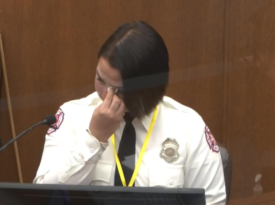 In this image from video, Minneapolis Firrefighter Genevieve Hansen, wipes her eyes as she testifies as Hennepin County Judge Peter Cahill presides Tuesday, March 30, 2021, in the trial of former Minneapolis police Officer Derek Chauvin, in the May 25, 2020, death of George Floyd at the Hennepin County Courthouse in Minneapolis, Minn. (Court TV via AP, Pool)