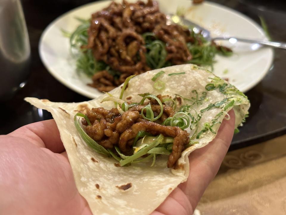 用蔥餅包著「京醬肉絲」吃，甜甜鹹鹹的滋味，很搭。（340元／份）