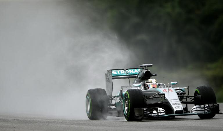 Lewis Hamilton powers his car in the rain during qualifying for the Formula One Malaysian Grand Prix in Sepang on March 28, 2015